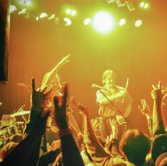 a group of people standing on top of a stage with their hands in the air