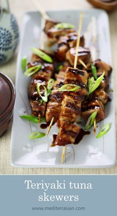 a plate with skewered meat and vegetables on it