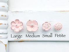 five small pink flowers on a white painted frame with the words large medium small pettite