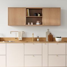 a kitchen with white cabinets and wooden counter tops on the wall above it is a sink