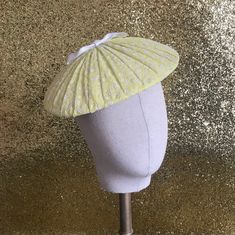 This sweet little 'plateau' style cocktail hat has been inspired by styles of the 1950s. The hand-blocked buckram base has been covered with a layer of crepe before being carefully overlayed with a hand-pleated layer of genuine vintage 1950s flocked organza in cheerful sunshine yellow with a scattering of tiny flowers all over it and topped off with a sweet little bow in white grosgrain ribbon - simply adorable! The hat has been fitted with a handmade wireframe that gently grips the head keeping Retro Fitted Summer Fascinator, Retro Summer Evening Hat, Retro Party Hats For Spring, Retro Party Hat For Spring, Retro Short Brim Fascinator For Kentucky Derby, Fitted Mini Hats For Vintage Events In Spring, Fitted Mini Hats For Spring Vintage Events, Retro Spring Fascinator Hat, Retro Fitted Fascinator With Curved Brim