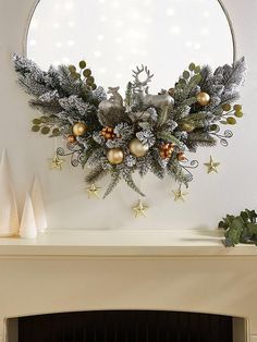 a fireplace mantel decorated for christmas with silver and gold decorations