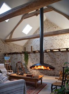 a living room filled with furniture and a fire place in the middle of the room