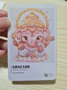 a person holding up a card with an image of a ganesha on it