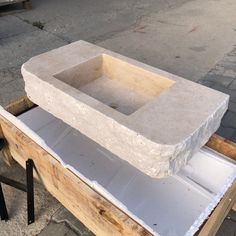 a stone sink sitting on top of a wooden box