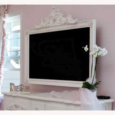 a white dresser with a large blackboard on it's side in a pink room