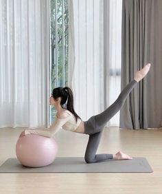 a woman is doing yoga on an exercise ball