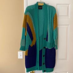 Roberto Collina Beautiful Green, Tan, And Royal Blue Knee Length Cardigan With Two Large Pockets On The Front. I’ve Only Worn This Item Once, It’s A Small But Fits Up To A Large. I’m Doing A Closet Clean Out So Get It While It’s Available. Super Gorgeous This Item Comes From A Smoke/Pet Free Home. Offers Are Welcome! Blue Knit Outerwear For Work, Trendy Blue Sweater Coat For Spring, Cozy Blue Sweater Coat For Layering, Casual Blue Sweater Coat For Layering, Blue Cardigan For Winter Layering, Blue Knit Cardigan For Layering, Blue Winter Cardigan For Layering, Chic Blue Cardigan For Fall, Blue V-neck Outerwear For Layering