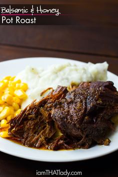 a white plate topped with meat and mashed potatoes next to corn on the cob