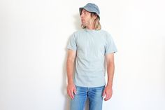 "Perfectly faded light blue all cotton Hanes Beefy T blank single stitch t shirt from the 1990s. Size on the tag is listed as a Large but fits more like a Medium, see measurements below to ensure a good fit. Good vintage condition, average signs of wear for age with a few horizontal fade marks at the bottom right waist Tag: Hanes Beefy T Made in USA Size on tag: Large Best fit: Medium - Small Material: Cotton Chest: 38\" (19\" pit to pit) Length: 29\" Pit to sleeve: 5.5\" Model is 6' and is a M/ Stitch T Shirt, Blank T Shirt, Blank T Shirts, White Undershirt, Sky Blue, Gender Neutral, Light Blue, Adult Outfits, Tops & Tees