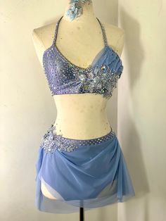 a woman's blue and white belly dance costume on a mannequin head