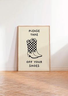 a framed sign that says please take off your shoes on the floor in front of a white wall