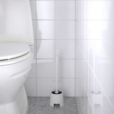 a white toilet sitting in a bathroom next to a roll of toilet paper