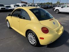 a yellow volkswagen beetle parked in a parking lot