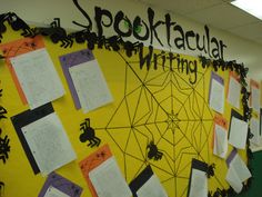 a bulletin board with writing on it and spider webs attached to the back wall