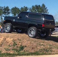 a black truck parked on top of a hill