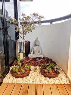 there is a small buddha statue in the center of two planters on top of rocks