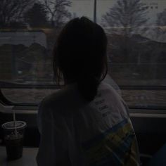 a woman sitting on a train looking out the window