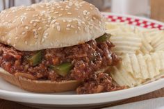 a sloppy joe sandwich and chips on a plate