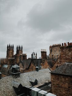 an old building with many spires on it's roof and some buildings in the background