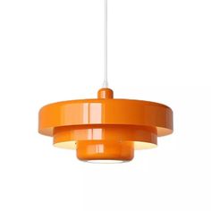 an orange pendant light hanging from a ceiling