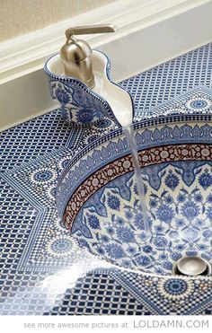 a blue and white sink with a faucet running from it's spout