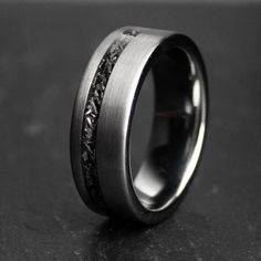 a wedding ring that has been made to look like it is decorated with silver and black stones