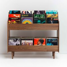 a wooden shelf with several books on it and two shelves holding various cds, magazines or dvds