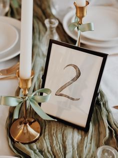 the table is set with two candles, plates and place settings for dinner guests to eat