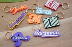 several different colored keychains on a wooden surface with the word nemo spelled in large letters