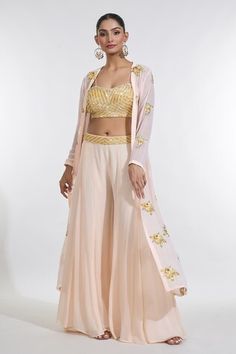 Peach full sleeves cape with sunny bloom sequin-cutdana embroidery. Paired with a sequin-cutdana chevron embroidered blouse and an embroidered waistband sharara. - Aza Fashions Fitted Front Open Sharara With Resham Embroidery, Fitted Front Open Palazzo Set, Fitted Front Open Palazzo Set With Zari Work, Fitted Front Open Sharara With Dupatta, Fitted Front Open Choli For Reception, Fitted Anarkali Set With Front Open, Navratri Front Open Fitted Sharara, Fitted Front Open Sharara For Designer Wear, Fitted Front Open Georgette Choli