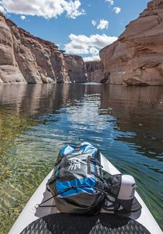 a kayak on the water with a backpack strapped to it's front end