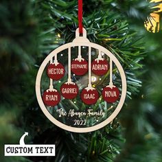 personalized christmas ornament hanging on a tree with red baubles and lights