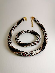 two black, white and red necklaces with gold clasps on a white surface