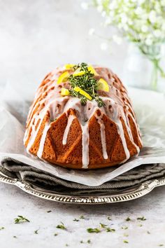 a bundt cake with lemon drizzle and icing on top sitting on a plate