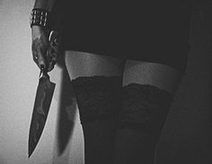 a woman holding a knife in her right hand and wearing thigh high garters