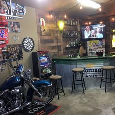 a motorcycle is parked in front of a bar with two televisions on the wall