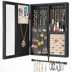 an open jewelry box with necklaces, bracelets and earrings hanging from it's sides