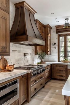 a kitchen with wooden cabinets and white counter tops, an oven hood over the stove