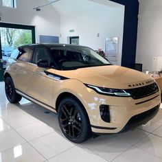 a white land rover in a showroom with black rims on the front and sides