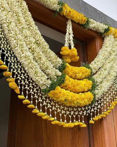 yellow and white flowers are hanging from a door