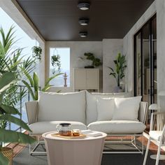 a white couch sitting on top of a wooden floor next to a table and potted plant