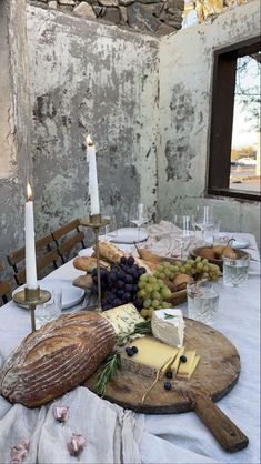 a table with cheese, bread and grapes on it