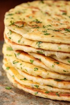 a stack of flatbreads with herbs on top are sitting on a countertop