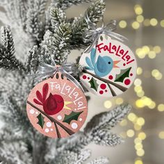 two ornaments are hanging from a christmas tree