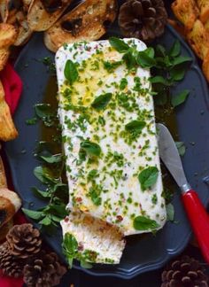 a piece of fish on a blue plate surrounded by pine cones and other food items