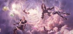 three women are flying through the air in front of clouds