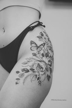 black and white photo of a woman's stomach with flowers on it, showing the side part of her body