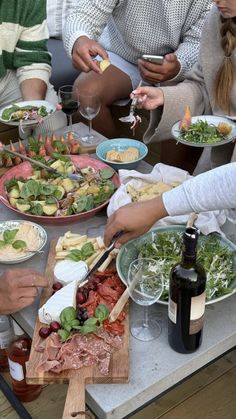 several people sitting at a table with plates of food