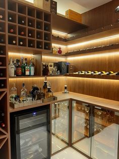 a wine cellar filled with lots of bottles and glasses on top of wooden shelving